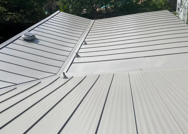 Solar attic fan installed on a metal roof for Roof Ventilation in Brush